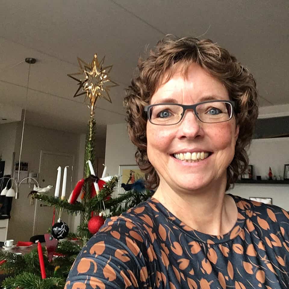 kvinde i stue med juletræ i baggrunden