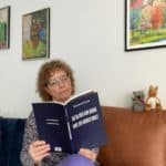 kvinde sidder i sofa og læser i bog