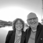 sort hvid billede af mand og kvinde ved havnekaj
