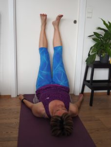 Sænk skuldre og ryg mod yogamåtten og sving benene op